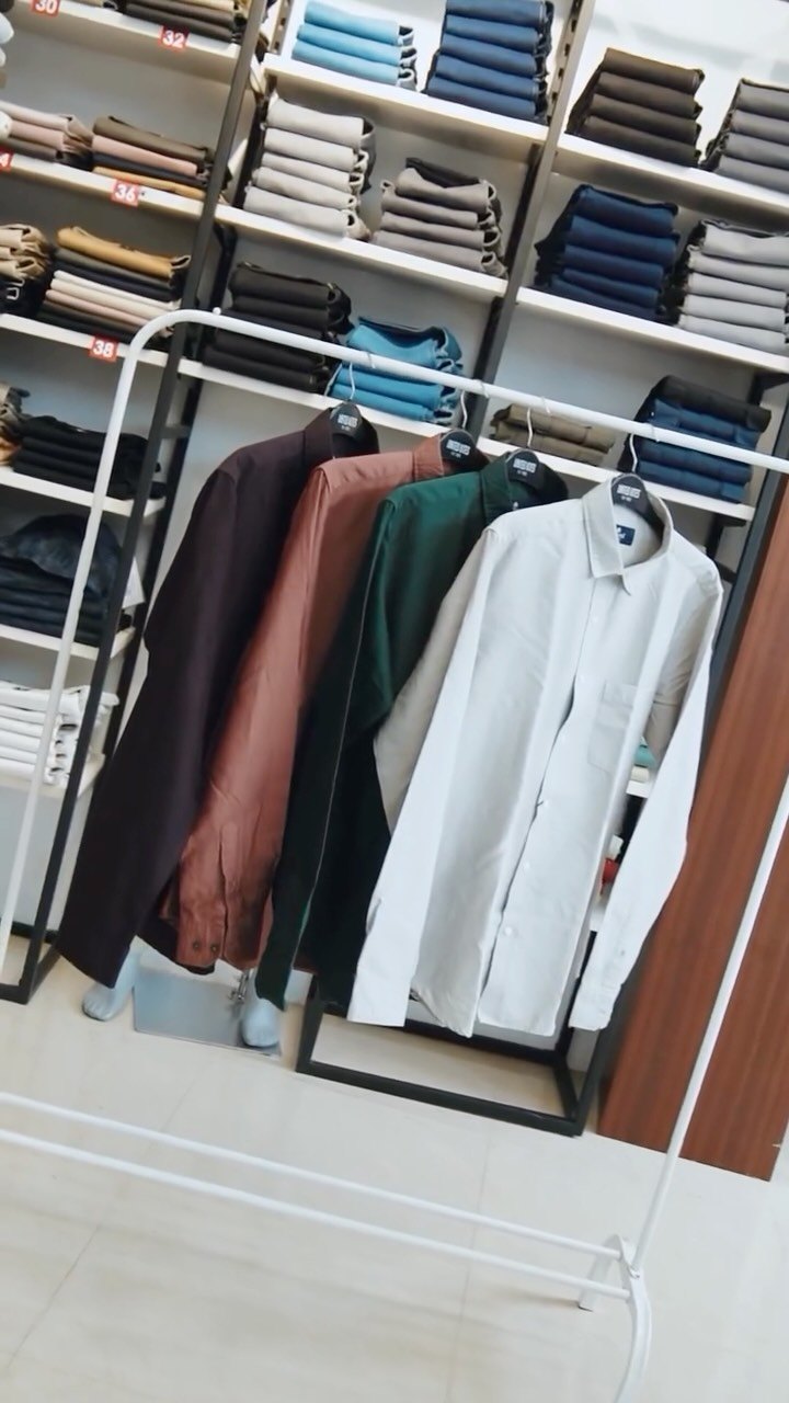 Rack of shirts and folded trousers in store